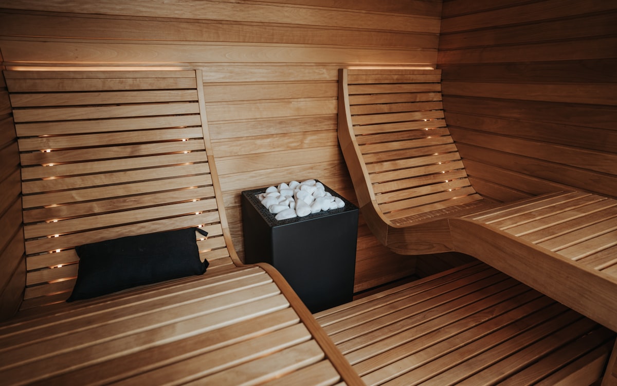 Wooden dry sauna interior with stone heater and warm benches