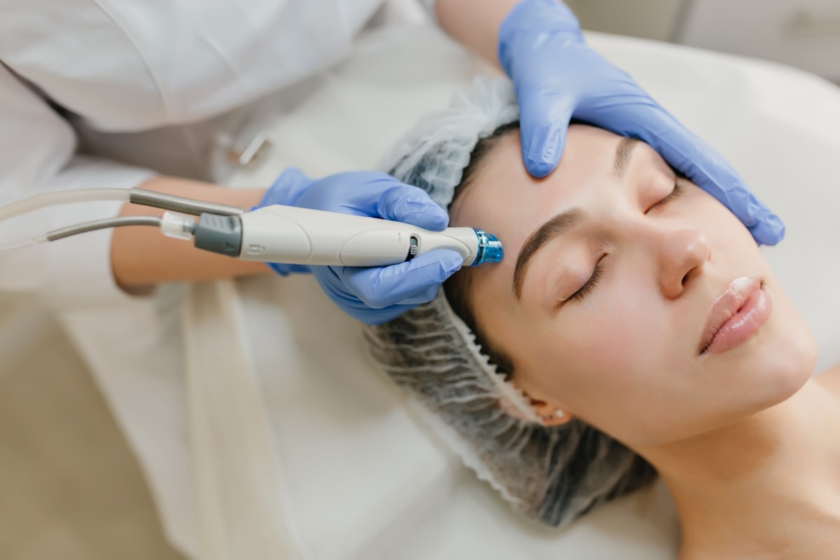 Hydrafacial vortex tip device being applied to woman receiving facial in clinical setting