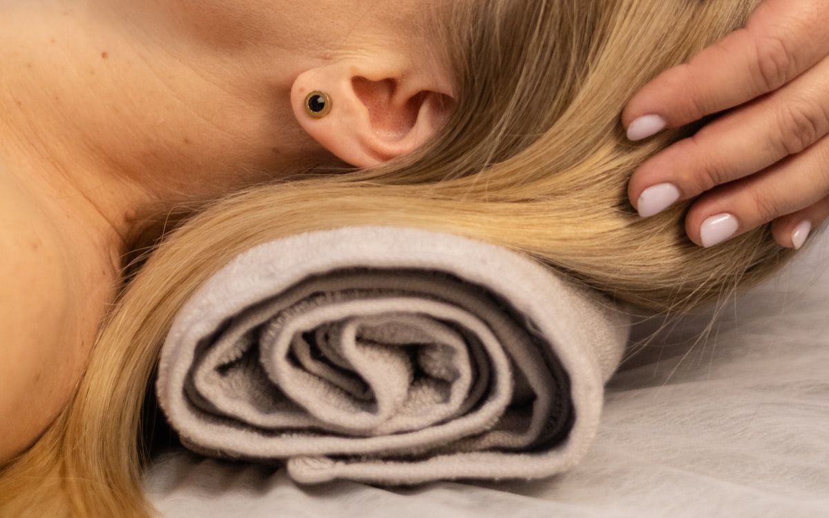 Quiet head-and-scalp therapy moment, hands working through hair on towel